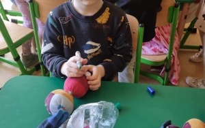 Chłopczyk rysuje oczka zajączkowi