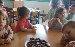 Dzieci siedzą przy talerzu z piernikami