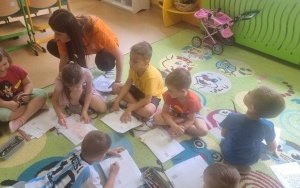 Dzieci kolorują na dywanie